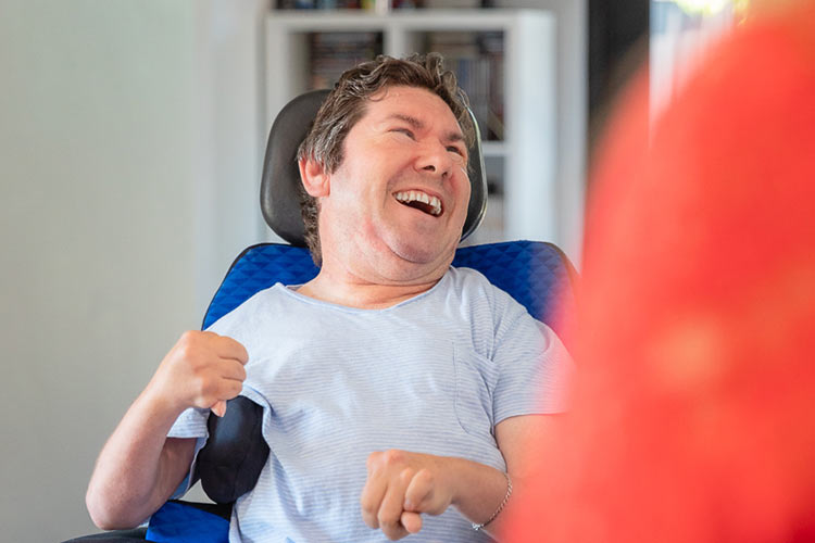 Disability activities for adults - Person in a wheelchair smiling.